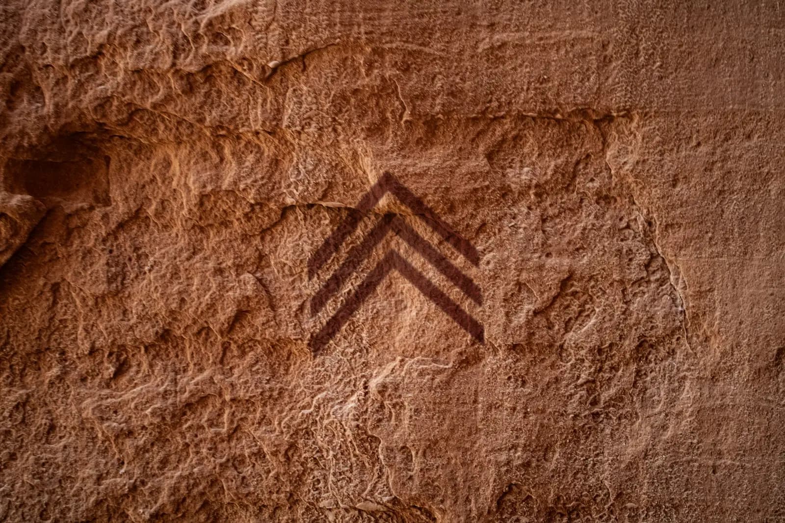 Le logo d'Ominin peint à l'ocre sur une paroi